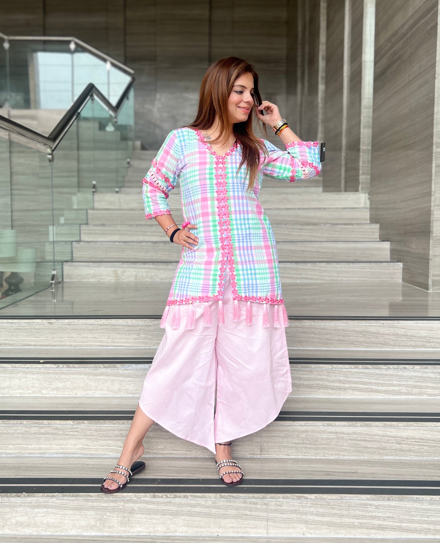 Woman wearing a pastel checkered kurta with tassel detailing and light pink wide-leg pants – stylish summer fusion co-ord for women