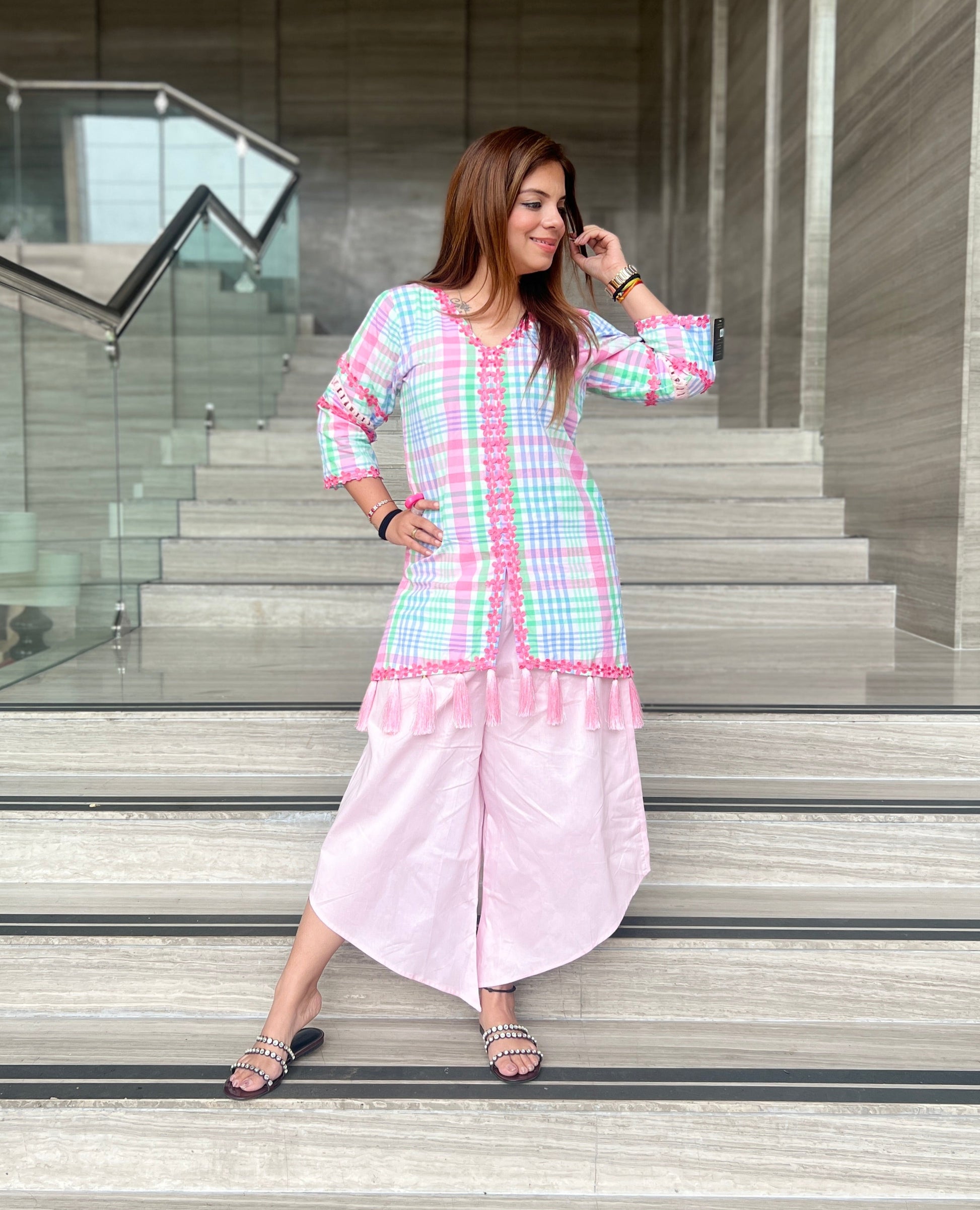Woman wearing a pastel checkered kurta with tassel detailing and light pink wide-leg pants – stylish summer fusion co-ord for women